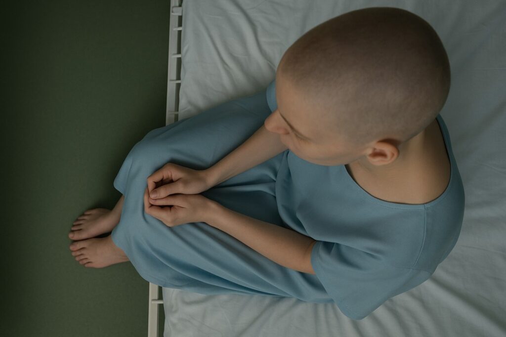 Cancer patient sitting on hospital bed during consultation for BRAF colorectal cancer treatment